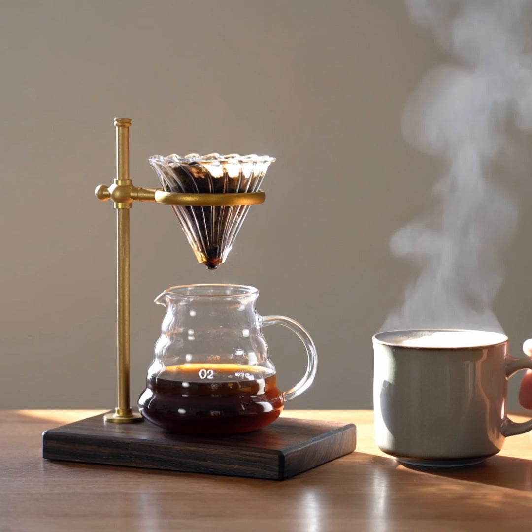 Copper pour-over stand on walnut with steaming mug