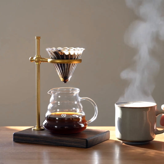 Copper pour-over stand on walnut with steaming mug